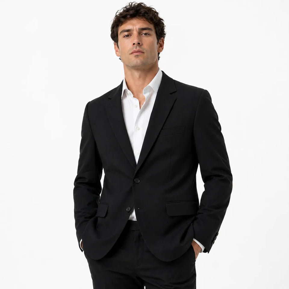 Man wearing a black suit and white shirt on a white background