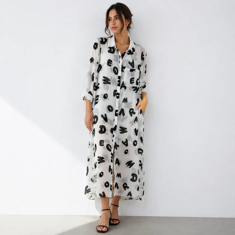 Woman wearing a long, patterned dress against a white background