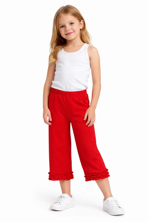 Young girl wearing a white top and red pants on a white background