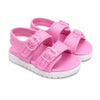 A pair of pink double-strap children's sandals with clear plastic buckle closures and white soles, shown on a plain white background.