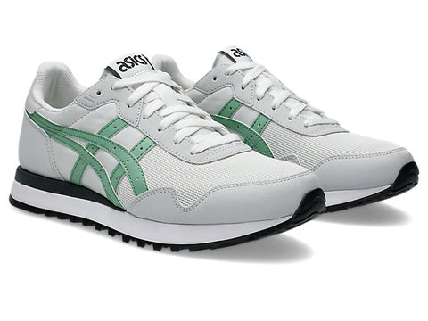 White and green sneakers with black soles on a white background