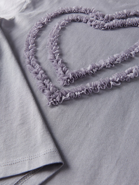 Purple ruffled trim on a light gray fabric background