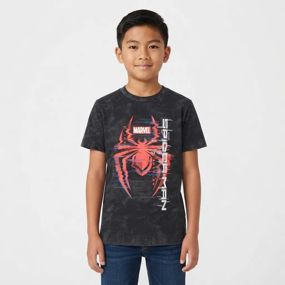 A young boy wearing a dark gray Marvel Spider-Man t-shirt with a red and white graphic print, paired with blue jeans, standing against a light gray background.