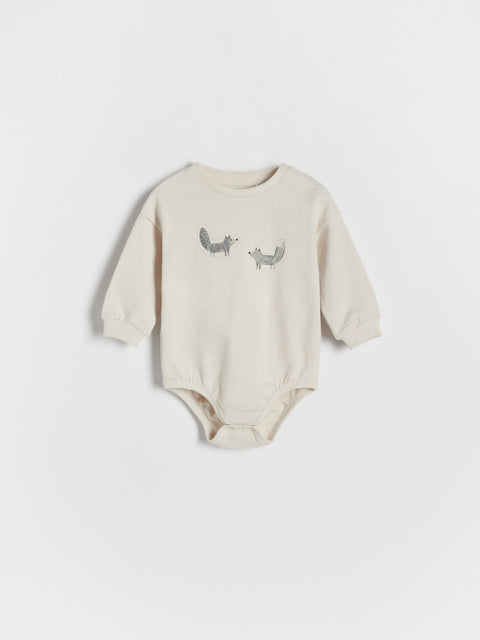 Beige baby bodysuit with printed design on a white background