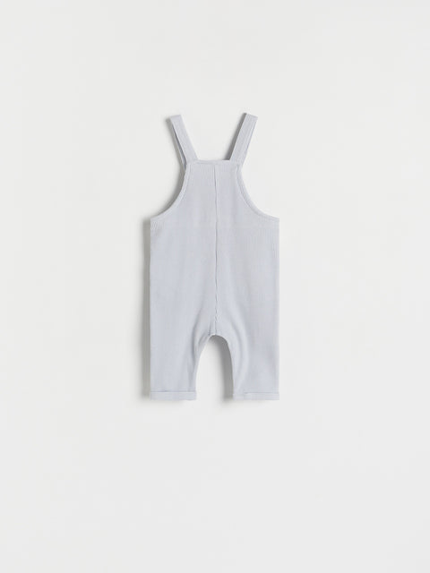 White baby romper with straps on a light gray background
