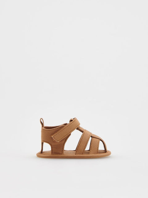 Tan sandal on a light gray background