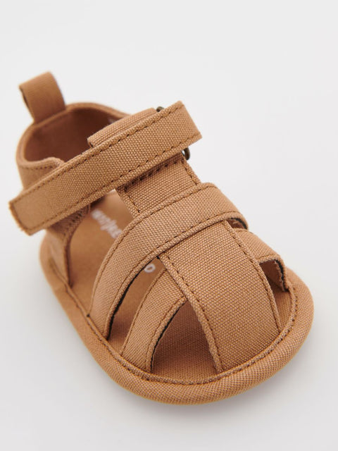 Brown baby sandal with a strap on a white background