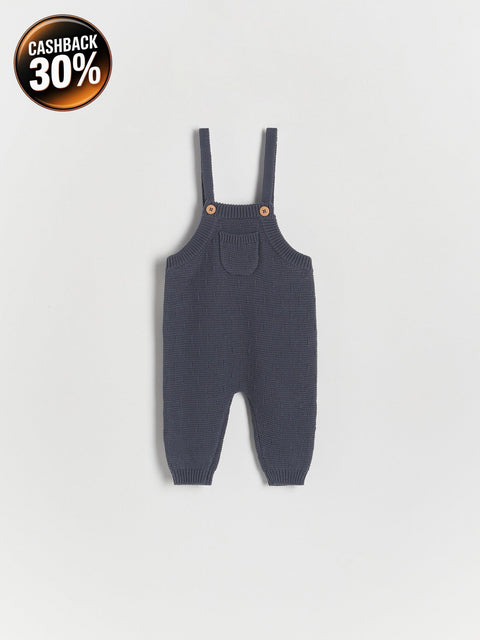 Dark gray knitted baby romper with suspenders on a light gray background