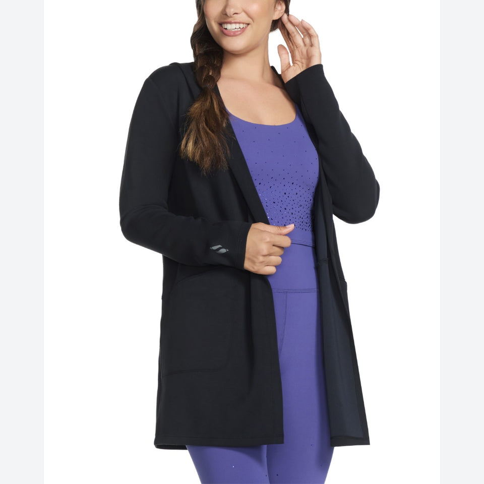 Woman wearing a black cardigan over a purple outfit on a white background