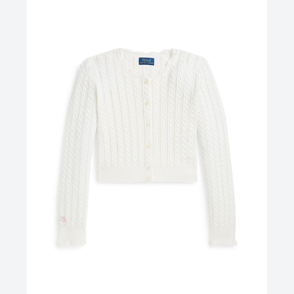 A white cable-knit cropped cardigan sweater with a button-up front, long sleeves, and a small embroidered pink bow on the left cuff, shown flat against a white background.