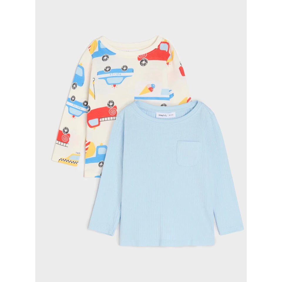 Two children's long-sleeve knit tops laid flat on a light gray background. The front top is light blue with a chest pocket, and the back top is cream with a colorful car print in red, blue, and yellow.