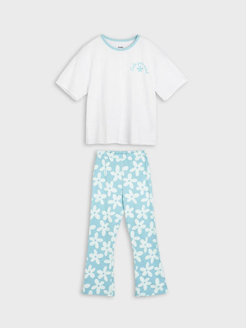 White t-shirt and light blue floral pants on a white background