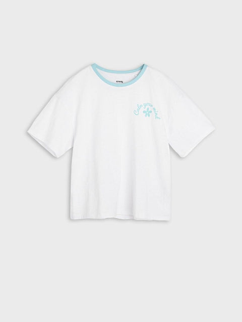 White t-shirt with a small graphic on a light gray background
