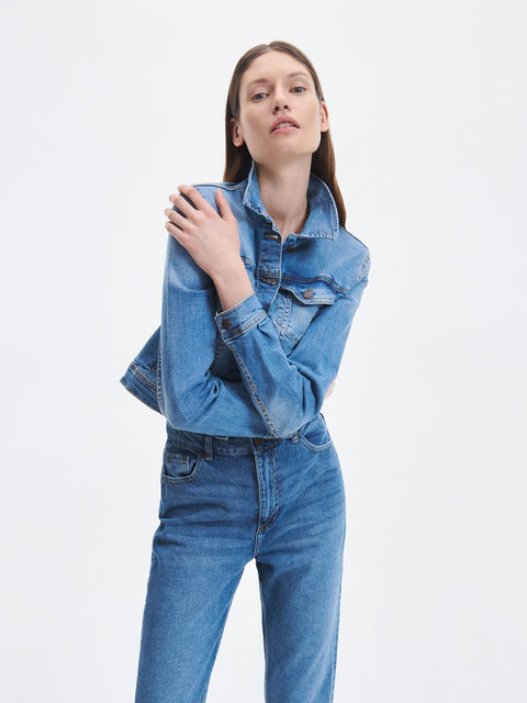 Woman wearing a denim jacket and jeans on a white background