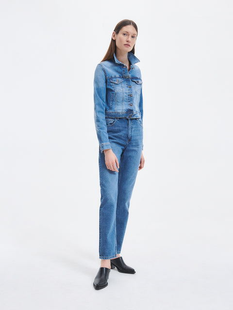 Woman wearing a blue denim outfit on a white background