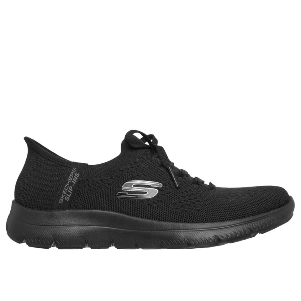 A black Skechers slip-on walking shoe with a textured knit upper, black laces, and a silver logo on the side, shown against a plain white background.