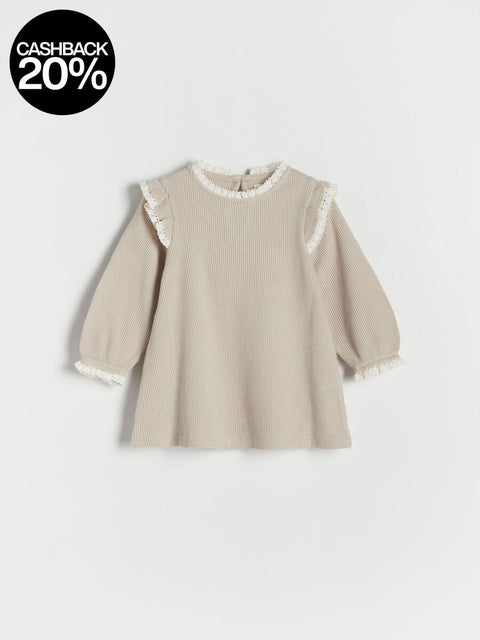 Beige ribbed sweater with lace trim on a white background