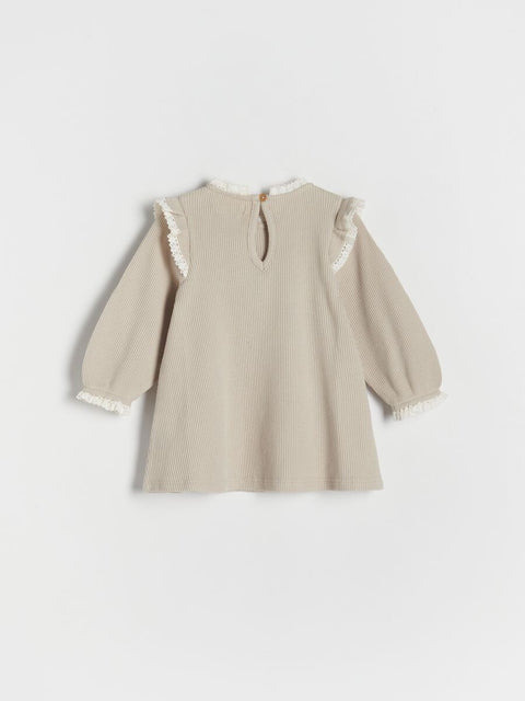 Beige dress with lace details on a white background