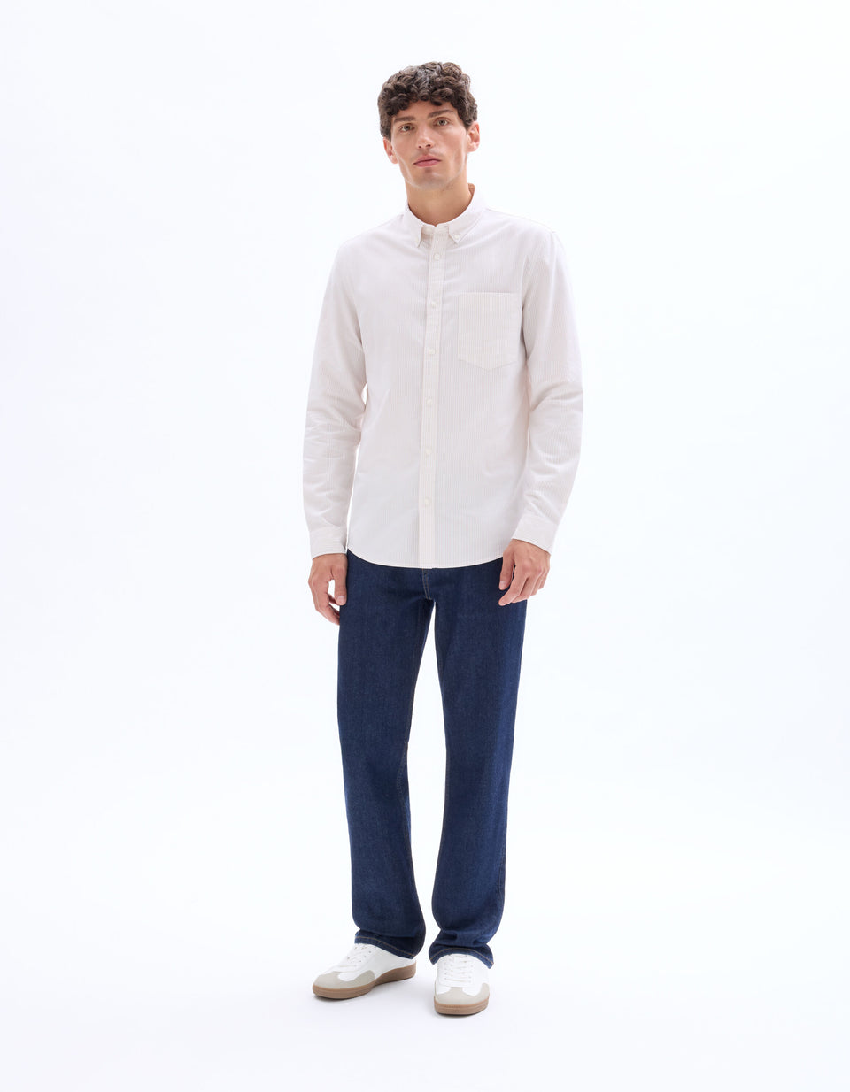 Man wearing a white shirt and blue jeans on a white background