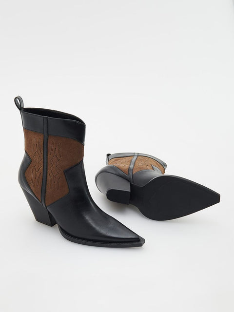 Black leather ankle boots with brown accents on a white background