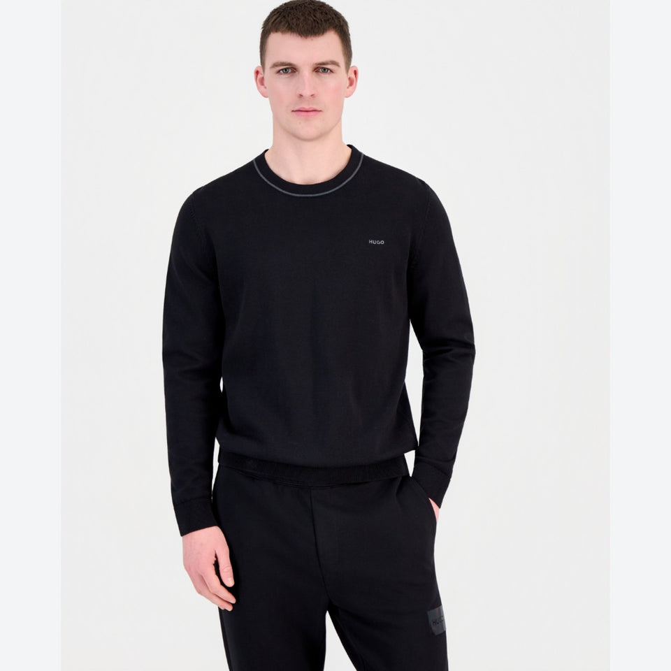 Man wearing a black long-sleeve shirt and pants on a white background