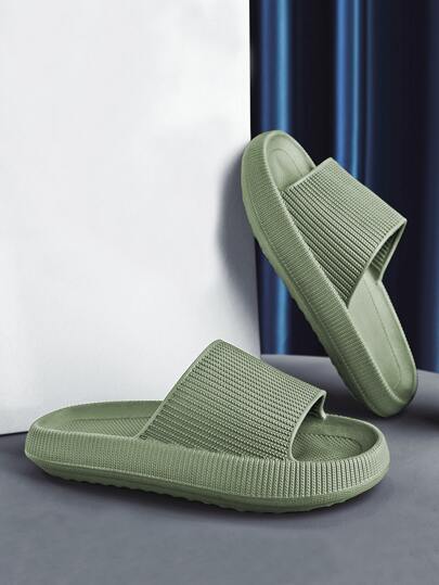 Pair of green slides on a gray surface with a white and blue curtain background