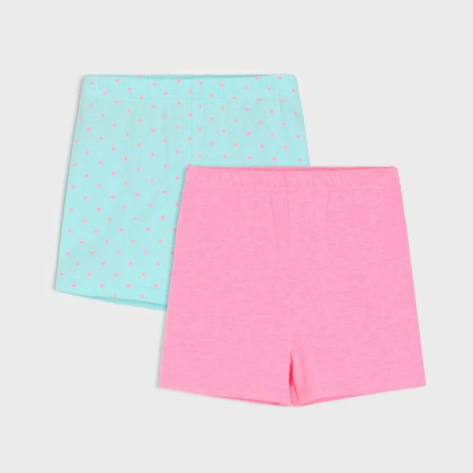 Two pairs of children's shorts in a flat-lay arrangement on a light gray background. The top pair is light aqua blue with small pink polka dots, and the bottom pair is solid bright pink.
