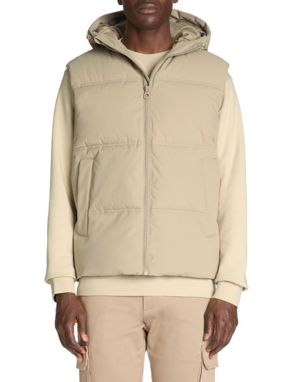 Man wearing a beige puffer jacket with a hood on a white background