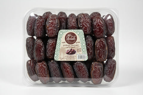 Packaged dates with a visible brand label held by a hand.