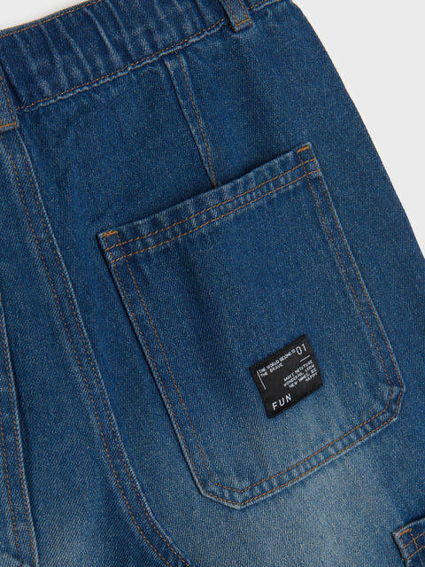 Close-up of blue denim pants with a brand label on a white background