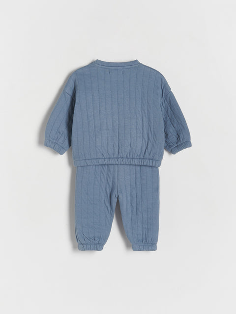 Blue baby outfit with long-sleeve top and pants on a light gray background