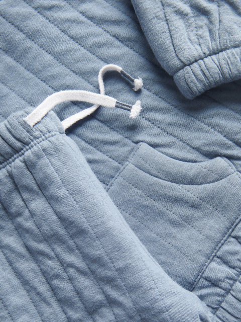 Light blue textured fabric with a hanger on a matching fabric background