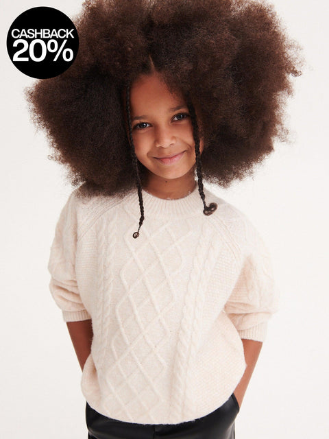 Child wearing a cream cable knit sweater with a cashback 20% offer badge.