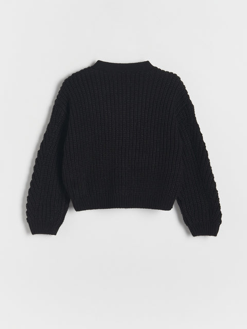 Black ribbed sweater on a light gray background