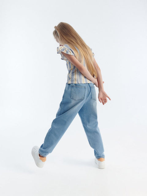 Person wearing a striped shirt and light blue jeans on a white background