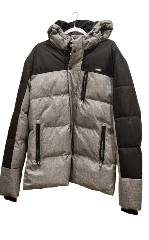 Gray and black puffer jacket on a hanger against a stone wall background