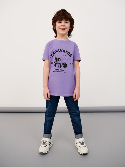 Child wearing a purple t-shirt with text and graphics, standing against a plain background