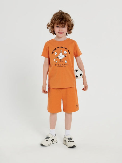 Child wearing an orange outfit with a graphic design on a white background