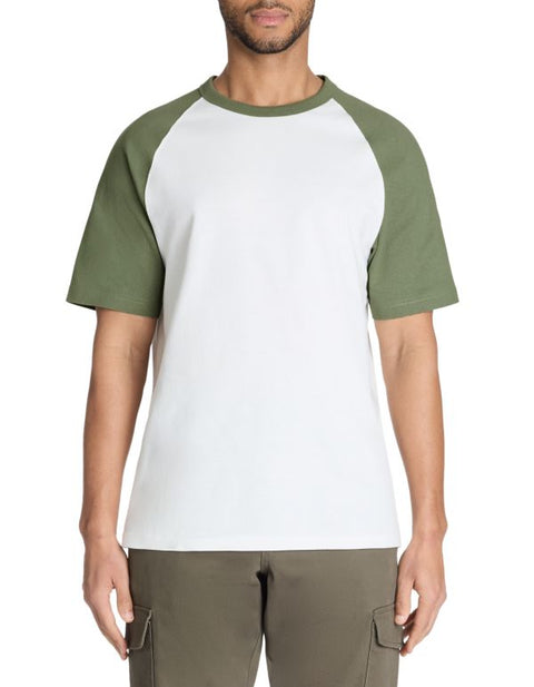 Person wearing a white and green baseball shirt with cargo pants on a white background