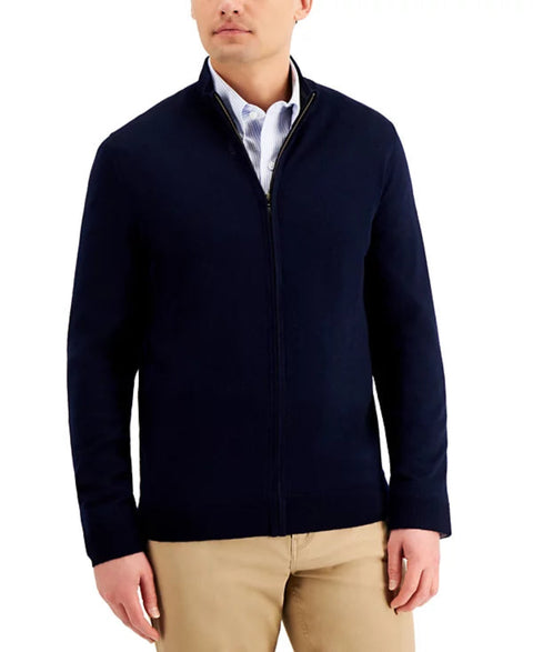 Man wearing a navy jacket over a white shirt with beige pants on a white background