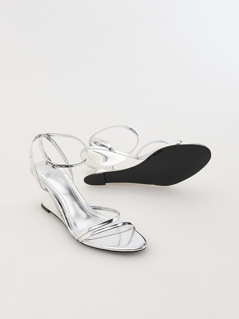 Clear high-heeled shoe with a black insole on a white background