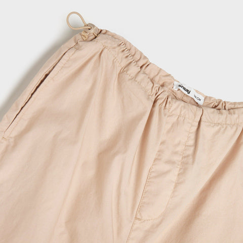 Beige pants with a brand label on a white background