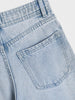 Close-up of light blue denim jeans with a pocket on a white background