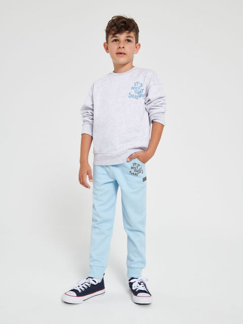 Child wearing a gray sweatshirt and light blue jeans on a white background