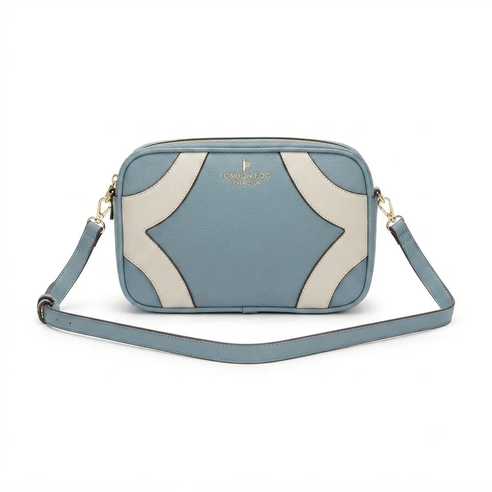 A light blue and cream crossbody camera bag with a geometric pattern, gold-tone hardware, and a matching blue strap, shown on a white background.