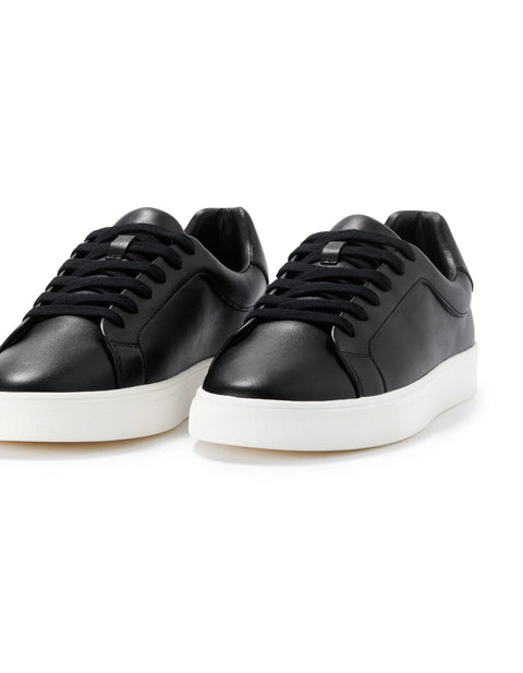 Black sneakers with white soles on a white background