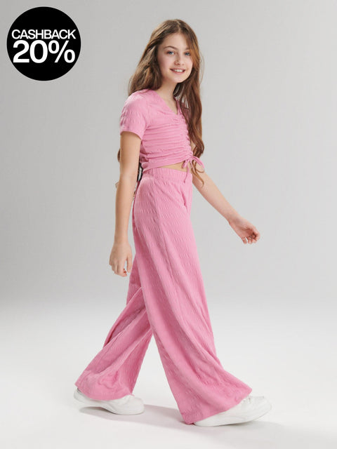 Girl wearing a pink outfit on a white background with a cashback offer overlay.