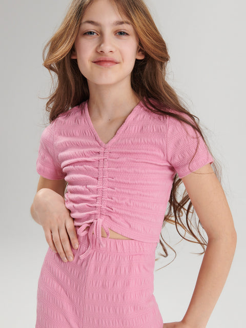 Young girl wearing a pink dress with a white background