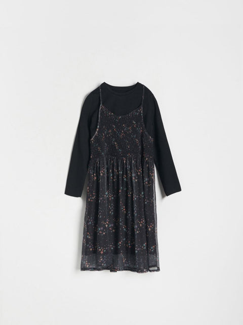 Black long-sleeve top and floral-patterned dress on a white background