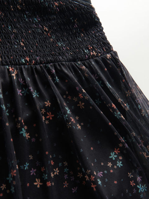 Black dress with colorful floral pattern on a white background